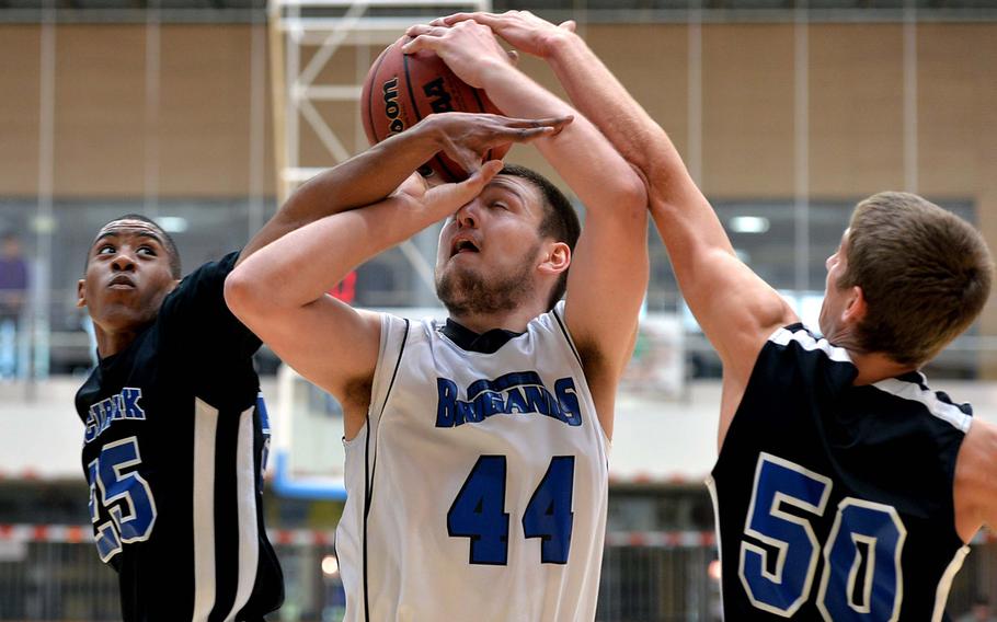 Matt Proulx of Brussels gets caught up in the Incirlik defense of Jonathan Catchings, left, and Patrick Ostrand in the Division III final at the DODDS-Europe basketball championships in Wiesbaden, Germany, Saturday, Feb. 22, 2014. Fouled on the play, Proulx made both free throws as Brussels took the title with a 41-33 win.