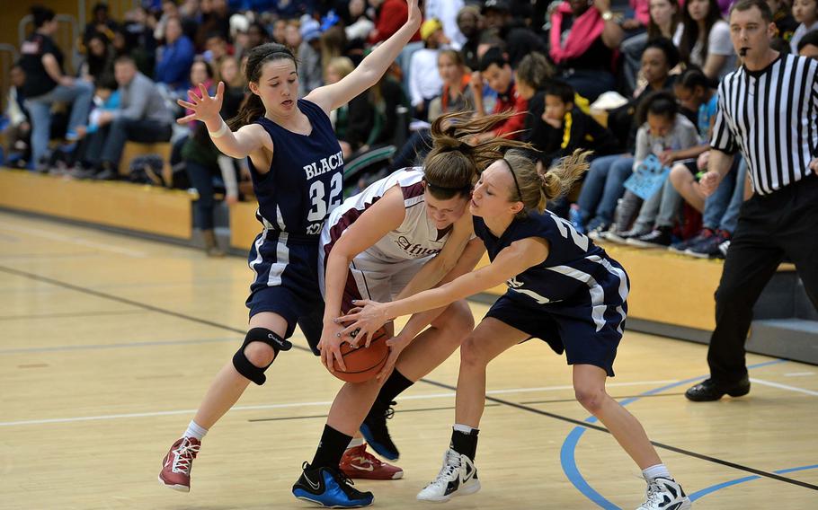 AFNORTH's Grace Phillips, center, fights for the ball with Black Forest Academy's Elyssa Brauer, right, and Hannah Harrop in the Division II final at the DODDS-Europe basketball championships in Wiesbaden, Germany, Saturday, Feb. 22, 2014. BFA won 19-13.