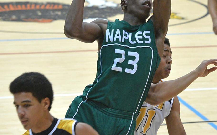 Jayontray Grogan of Naples goes to the basket between Vicenza's Tyess Chatman, left, and Randall Bagtas in the Division II title game at the DODDS-Europe basketball championships in Wiesbaden, Germany, Saturday, Feb. 22, 2014. Vicenza beat Naples 75-45 for the title.