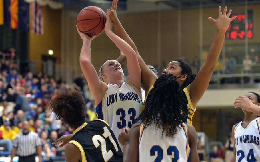 Wiesbaden's Catherine Klein shoots against Patch's Breanna Rodriguez-Jeff in the Division I title game at the DODDS-Europe basketball championships in Wiesbaden, Germany, Saturday, Feb. 22, 2014. Wiesbaden beat Patch 40-17. In the foreground are Aliya Brazelton, left, and Marquala Scott.