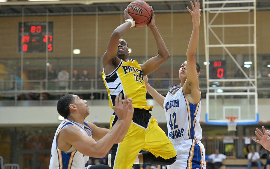 Patch's Kelvin Brown goes to the basket between Wiesbaden's Kelsey Thomas, left, and Justin Whatley in the Division I title game at the DODDS-Europe basketball championships in Wiesbaden, Germany, Saturday, Feb. 22, 2014. Patch beat the Warriors 60-56.