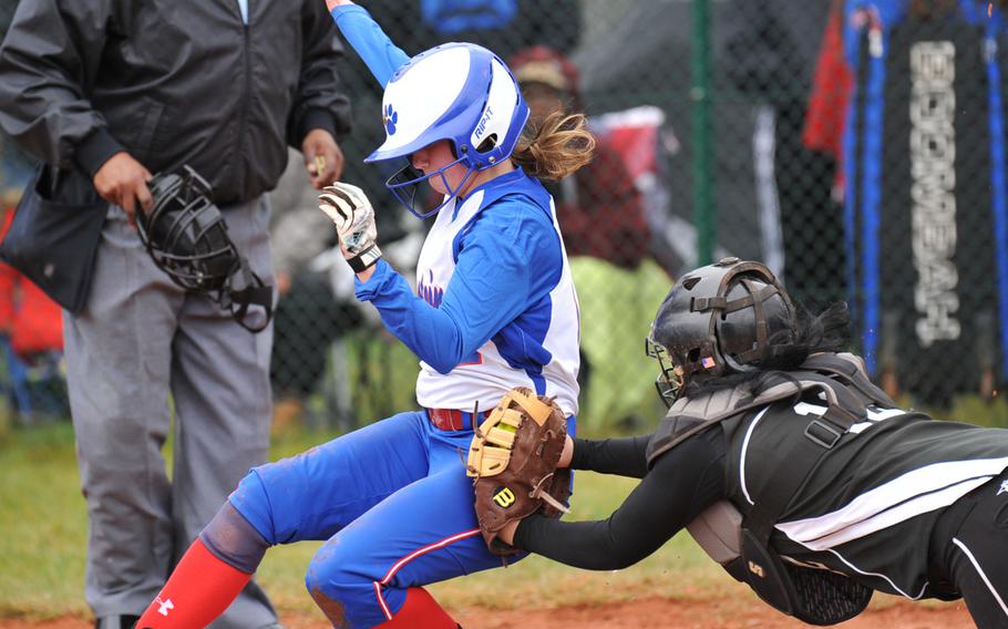 Vilseck catcher Tania Powers makes a leaping attempt to tag out Ramstein's Kristina Poe in the first game of a doubleheader at Ramstein, Germany, Saturday, March 22, 2014. Ramstein beat the Falcons 15-1 in both teams' season openers. Poe scored.