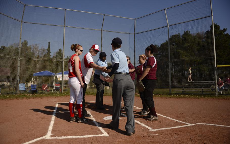 From left to right: Kaiserslautern team captain Megann Schultz and her head coach John Culbreth meet with Tim Easter, umpire in charge, Michelle Raether, base umpire, Baumholder head coach Stacie Sais, partially hidden, and Baumholder team captains, Megan Brown and Faith Diaz at home plate to start a double header between visiting Baumholder at Kaiserslautern, Germany Saturday, March 29, 2014.