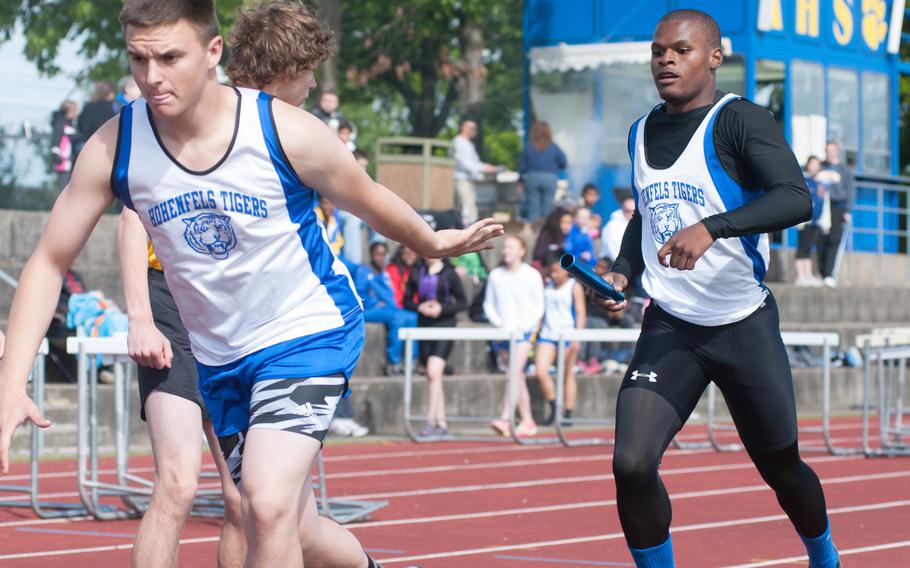 Hohenfels' Trevor Tufts awaits the passing of the baton from teammate Malik Jefferson Saturday, during the 4x800-meter relay at a track and field meet held at Ansbach, Germany. 