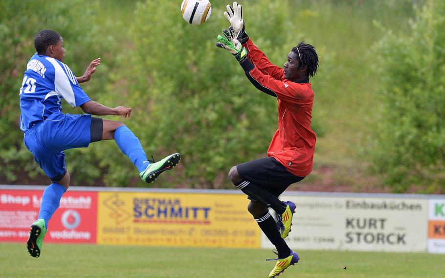 Wiesbaden's Asante Lattimore and Patch keeper Brandon Danielson try for the ball in a Division I pool game at the DODDS-Europe soccer championships in Reichenbach, Germany, Wednesday, May 21, 2014.
