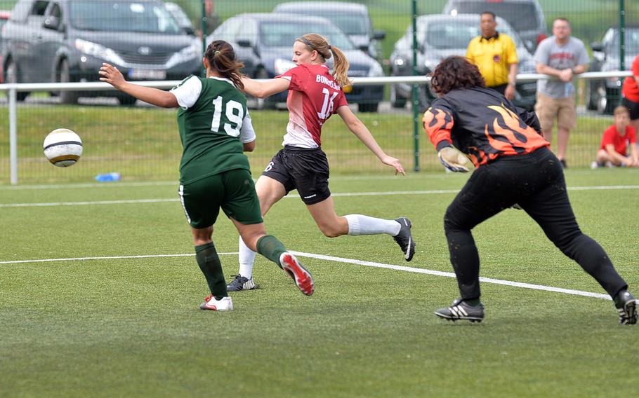 AFNORTH's Hope BonenClark, center, drives the ball past Alconbury's Dominique Joseph and keeper Leila Hall into the empty net for the 5-4 winning overtime goal in a Division II semifinal game at the DODDS-Europe soccer championships in Reichenbach, Germany, Wednesday, May 21, 2014. AFNORTH will face Naples in the championship game on Saturday.