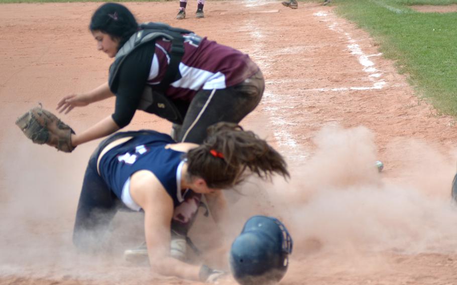 Lakenheath's Arianna Lemieux comes full steam to home plate against Vilseck catcher Janin Powers in day one of pool play at the DODDS-Europe softball championships in Kaiserslautern, Germany on May 22, 2014.  Lakenheath defeated Vilseck 5-3.