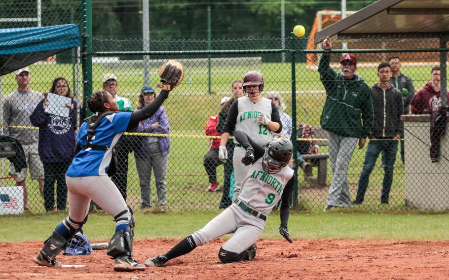 Rota's Audrenik Howard reaches for a high throw at the plate as Erica Balkculm slides in for AFNORTH's only run during their 8-1 meeting in pool play in the DODDS-Europe softball championships Friday, May 23, 2014.