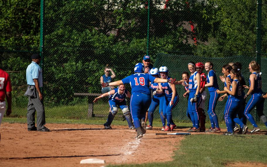 Ramstein's Brooke Strasbgerger is greeted at the plate by the rest of her team after smacking a home run in the Royals' 9-5 quarterfinal win over Kaiserslautern in the DODDS-Europe softball championships Friday.