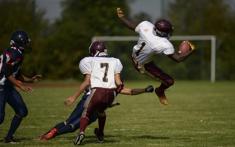 Baumholder's Demonte Fisher goes airborne in an athletic attempt to get around a Bitburg defender Saturday afternoon in the first game of the season at Bitburg. Bitburg went on the win the game with a score of 32-8.
