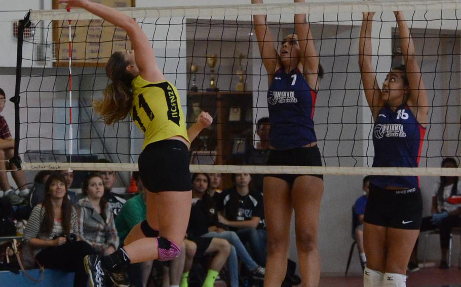 Vicenza's Brianna Baker attempts to spike the ball Saturday against Aviano's Viyanni Johnson, center, and Alana Masters during a match at Aviano Air Base, Italy. The Saints won two matches back-to-back, 3-1.