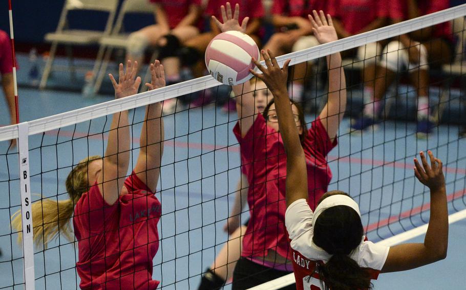 Kaiserslautern's Lashae Daniels pushes the ball over the net against two Lakenheath defenders Saturday, Oct. 4, 2014 during a volleyball match at Ramstein, Germany.