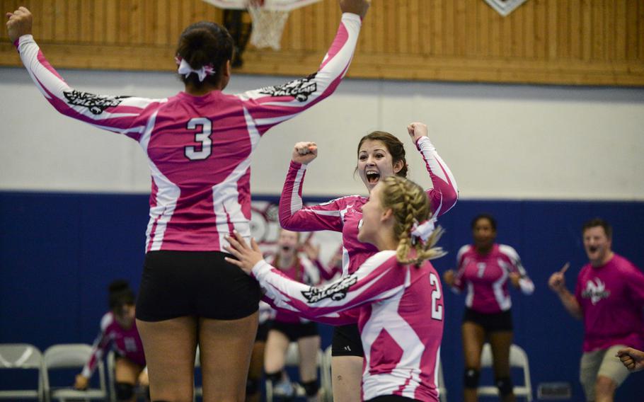 Vilseck's Amira Murry, left, Kaylee Luginbuhl, middle and partially hidden, and Taryn Sobey celebrate after defeating Ramstein in three sets Saturday, Oct. 4, 2014 at Ramstein, Germany.