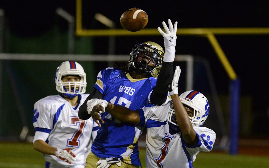 Wiesbaden's CJ Pridgen attempts a catch between two Ramstein defenders Friday, Oct. 10, 2014, at Wiesbaden, Germany. Ramstein was called for pass interference on the play.