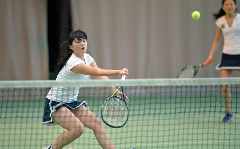 ISB's Megumi Ogasawara returns a shot against Wiesbaden as partner Maya Yoshihashi watches in the girls doubles final at the DODDS-Europe tennis championships in Wiesbaden, Germany, Saturday, Oct. 25, 2014. The ISB duo beat Wiesbaden's Jackie Renzi and Peyton Taylor 6-1, 7-5 to take the title.