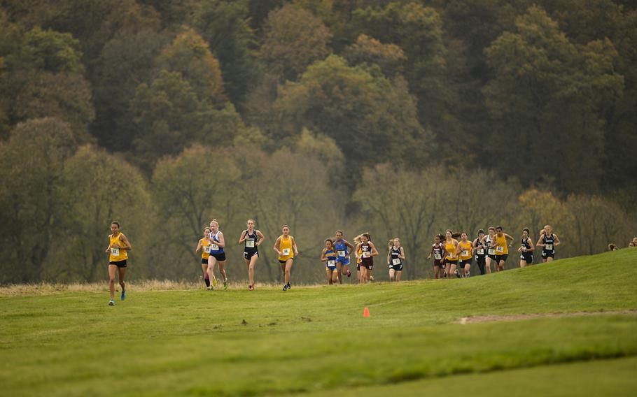 Competitors round a turn on the first lap of the DODDS-Europe cross country championship race at the Rolling Hills Golf Club in Baumholder, Germany, Saturday, Oct. 25, 2014.