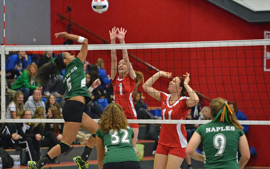 Leiena'ala Esperon of Naples, left, hits the ball over the net against the Kaiserslautern defense of Brooklynn Loposser, center, and Hannah Thomascall as teammates Skylar Evans and Amanda James, right, watch. Naples defeated Kaiserslautern 25-18, 25-7 in opening day action at the DODDS-Europe volleyball championships in Kaiserslautern, Thursday Oct. 30, 2014.