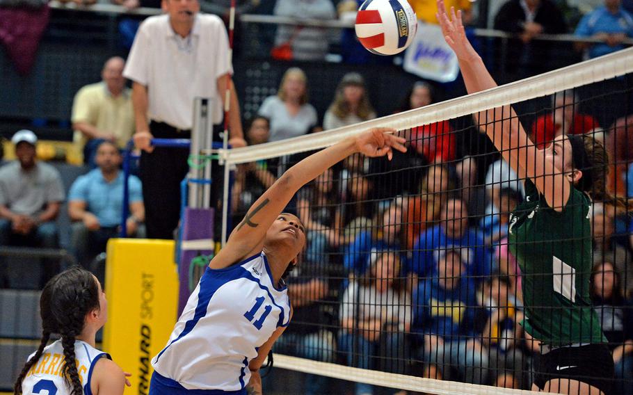 Wiesbaden's Cierra Martin, left, battles Naples' Jessica Wheeler at the net as teammate Andriana Ibanez, far left, watches. Wiesbaden beat Naples 19-25, 25-11, 25-14, 23-15, 16-14  for the Division I title at the DODDS-Europe volleyball championships in Ramstein, Germany, Saturday, Nov. 1, 2014. 