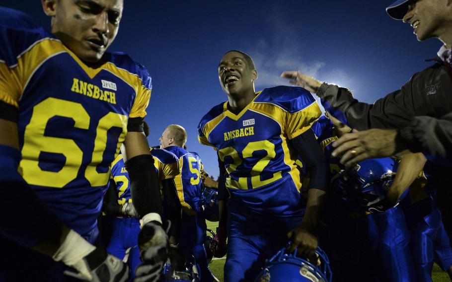 Ansbach's Roger Brownell, center, and Joxua Baughman, left,, celebrate after winning the 2014 DODDS-Europe DII football championship against Hohenfels in Kaiserslautern, Germany, Nov. 1, 2014.
