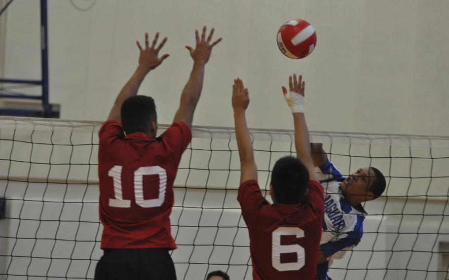 Sigonella's Chris Moore tries to get the ball past American Overseas School of Rome blockers Gregory China, left, and Yishu Weng. The Falcons won their third straight DODDS European Boys Volleyball Championship on Saturday, 26-24, 25-19, 25-19.

Kent Harris/Stars and Stripes