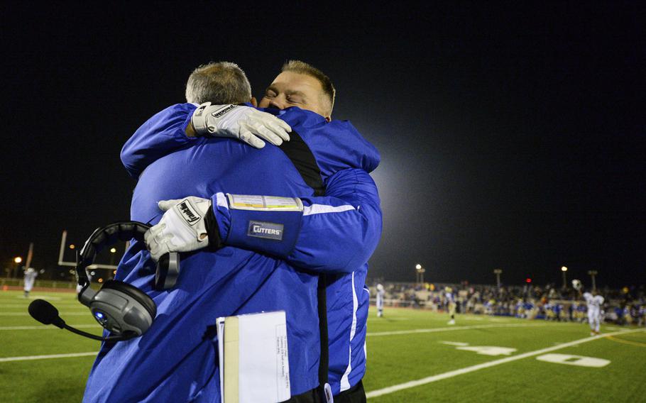 Ramstein's head coach Carlos Amponin get's a big hug from his assistant coach Carter Hollenbeck after winning the 2014 DODDS-Europe DI football championship against Wiesbaden in Kaiserslautern, Germany, Nov. 1, 2014.