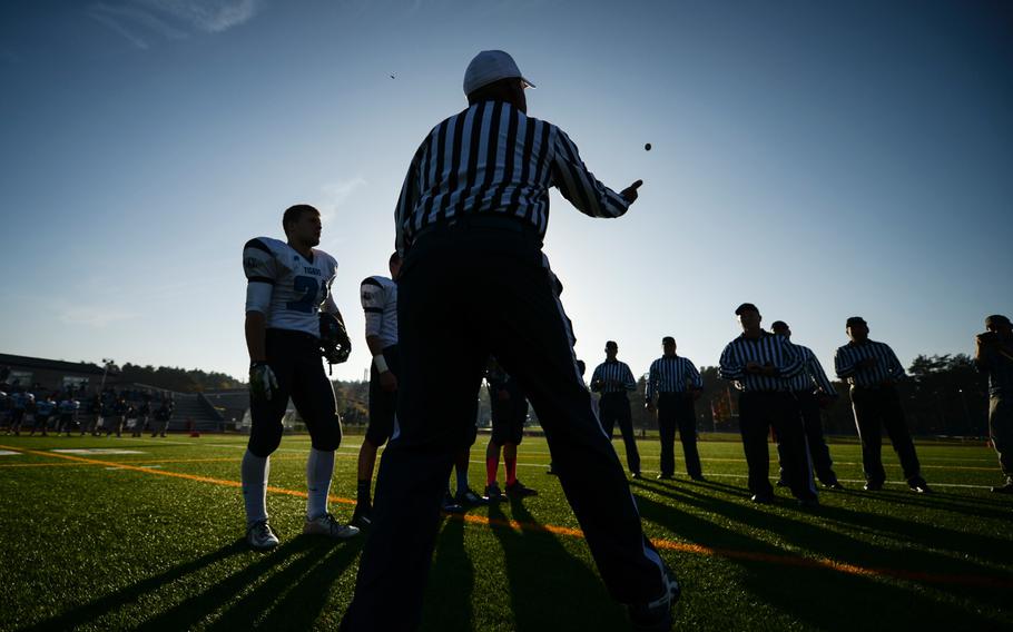 A referee conducts the coin toss to start the 2014 DODDS-Europe DII football championship with Ansbach facing Hohenfels in Kaiserslautern, Germany, Nov. 1, 2014.