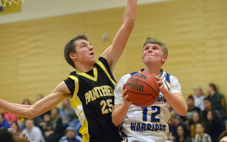 Wiesbaden's Gavin Adams goes to the basket against Patch's Colin Whitten. The Panthers beat the Warriors in Wiesbaden 53-44, Friday Jan. 16, 2015.