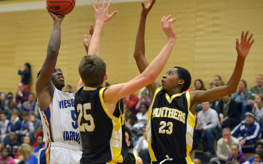 Wiesbaden's Anthony Little gets a shot off against the Patch defense of Colin Whitten and Robert Braswell. The Panthers beat the Warriors in Wiesbaden 53-44, Friday Jan. 16, 2015.