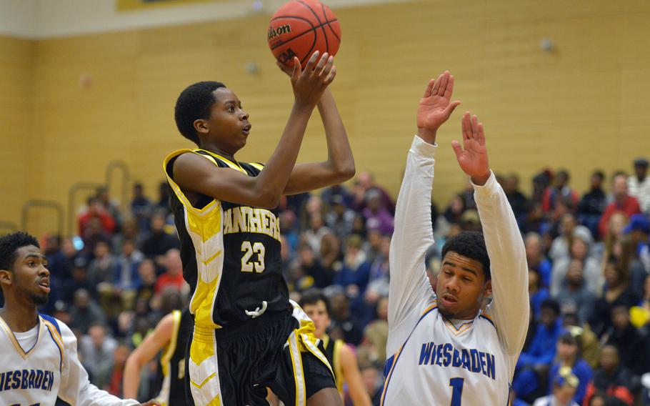 Patch's Robert Braswell shoots over Wiesbaden's Tim Cuthbert in the Panther's 53-44 win over the Warriors in Wiesbaden, Friday, Jan. 16, 2015.