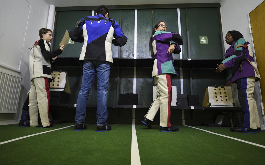 Members of the Kaiserslautern High School marksmanship team, from left to right, Emily Vose, Marco Walter, Valeria Santos and Belle Cyriaque, retrieve their targets for scoring during a practice session at their school's new four-lane range Tuesday afternoon, Jan. 27, 2015.

