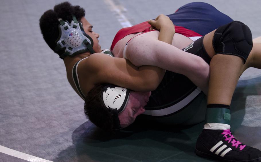 Alconbury's Dee Wilson cradles Bitburg's Ceth Haney during a wrestling meet at RAF Alconbury, England, on Saturday, Jan. 31, 2015. Wilson won the match due to a disqualification.