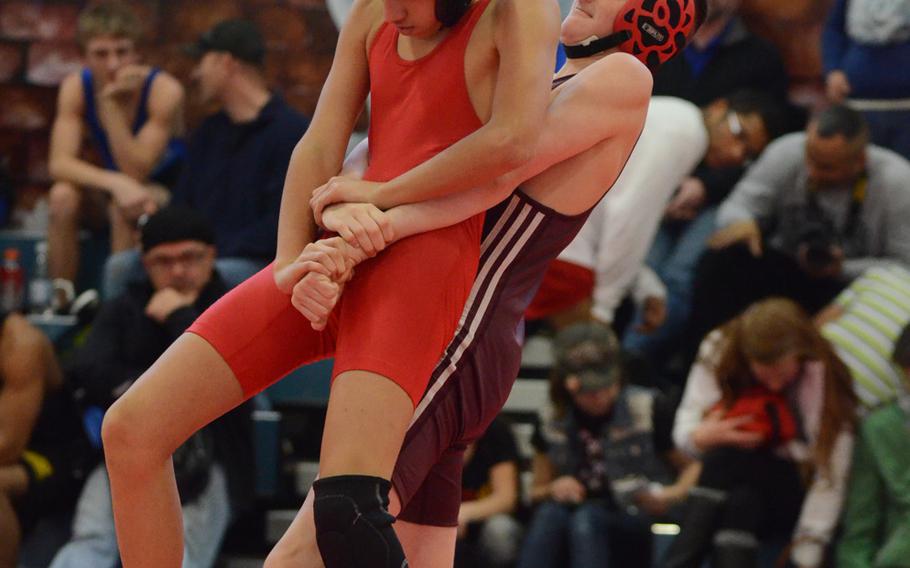 Aviano's Samir Safford is lifted off the ground by Vilseck's Chase Richardson on Saturday during a 106-pound match at the Southern sectional qualifiers at Aviano Air Base, Italy. Richardson won 8-2.