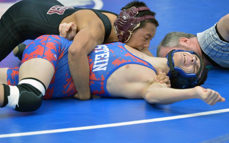 Vilseck's Mikhael Ragay, left, puts the pressure on Ramstein's Garrett Dean in a 126-pound match on opening day of the DODDS-Europe wrestling championships in Wiesbaden, Germany, Friday, Feb. 13, 2015. Ragay was the winner.