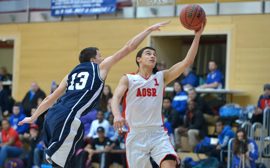 AOSR's Otis Reale gets past Bitburg's Colton Thomas in AOSR's 49-39 win in a Division II game on opening day of the DODDS-Europe basketball championships in Wiesbaden, Germany, Wednesday, Feb. 18, 2015.