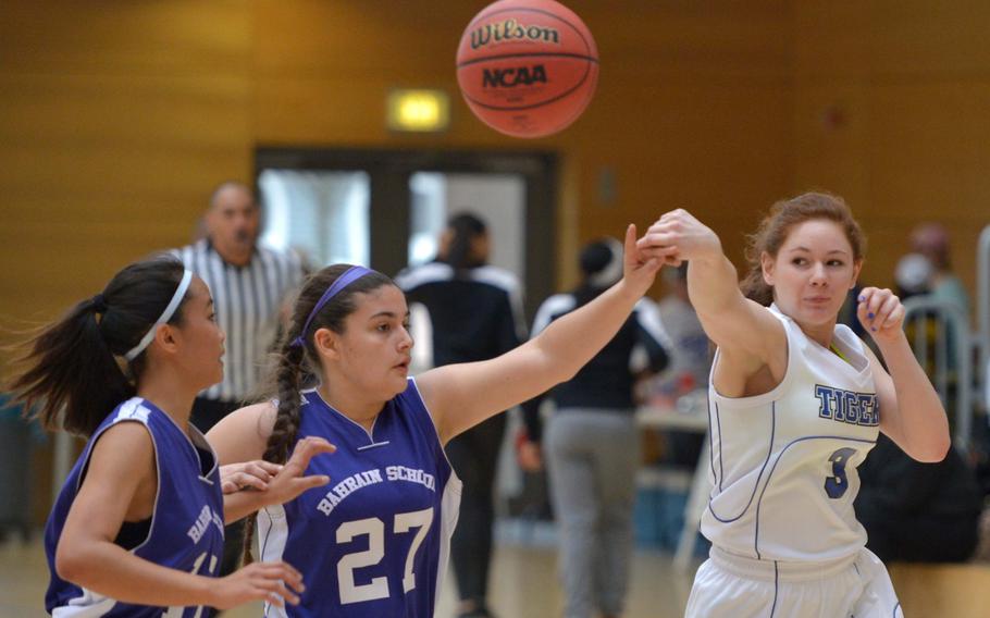 Jessie Garnez of Hohenfels, right, passes off to a teammate for an assist past Bahrain defenders Melissa Atienza, left, and Yaisa Coburn in a Division II game on opening day of the DODDS-Europe basketball championships in Wiesbaden, Germany, Wednesday, Feb. 18, 2015. Hohenfels won 31-10.