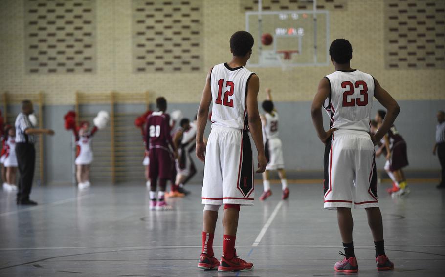 Kaiserslautern's Antwan Haynes, 12, and Ja'Markus Myles, 23, watch as they're teammate Jeremy Morgan sinks a game clinching free throw against Vilseck in the first day of DODDS-Europe tournament play, Wednesday, Feb. 18, 2015.