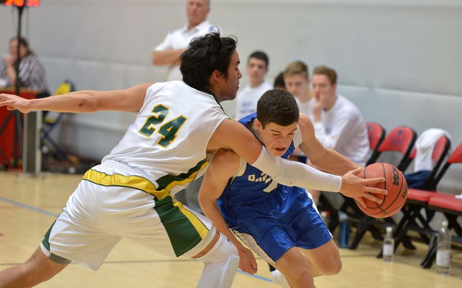 Michael DeFazio of Brussels drive against Alconbury's Fritz Sherenco in opening day Division III action at the DODDS-Europe basketball finals in Wiesbaden, Germany, Thursday, Feb. 19, 2015. Alconbury won 48-27.