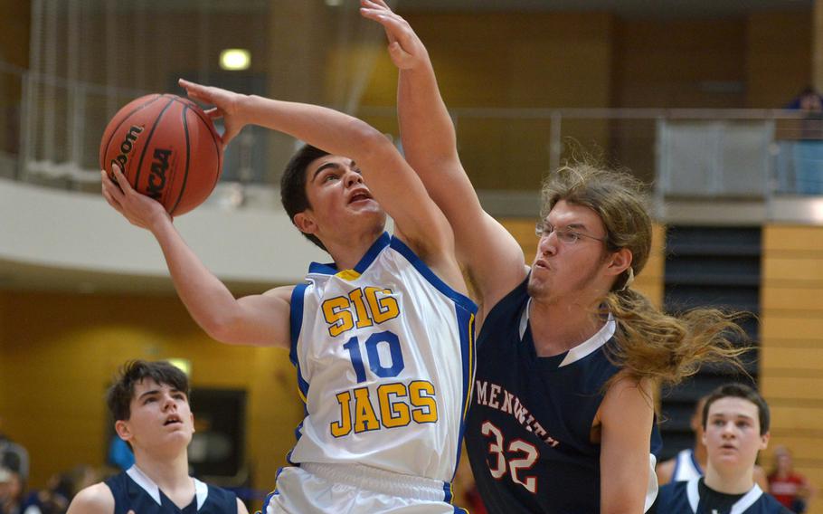 Sigonella's Zach DeSanto goes to the basket against Menwith Hill's Jason Brugman in opening day Division III action at the DODDS-Europe basketball finals in Wiesbaden, Germany, Thursday, Feb. 19, 2015. Sigonella defeated 48-9.