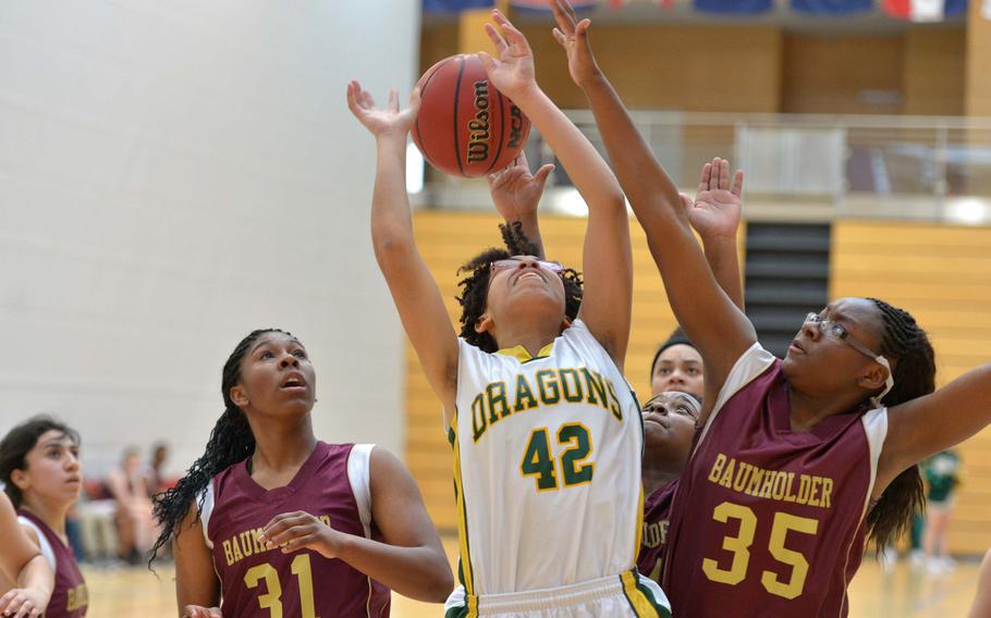 Baumholder's Imaya Sharpe, right, stops Alconbury's Harveysha Booker under the basket as teammateEliyah Tillman watches in opening day Division III action at the DODDS-Europe basketball finals in Wiesbaden, Germany, Thursday, Feb. 19, 2015. The third-seeded Bucs defeated the top-seeded Dragons 29-18.