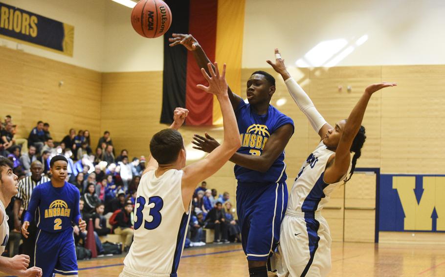 Ansbach's Cedric Page dishes the ball to a teammate over two Rota defenders in the semifinals of the DODDS-Europe tournament, Friday, Feb. 20, 2015.