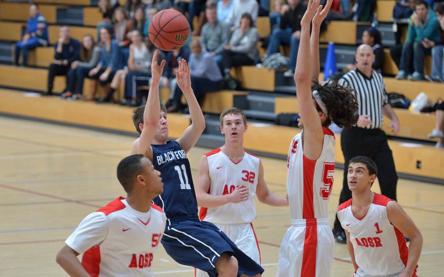 Black Forest Academy's Cameron Lockwood scores despite being fouled and surrounded by American Overseas School of Rome players. AOSR defeated BFA 63-40  in a Division II semifinal at the DODDS-Europe basketball championships in Wiesbaden, Germany, Friday, Feb. 20, 2015. 