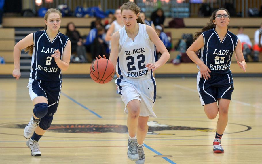 Black Forest Academy's Anna Kragt drives up the court on her way to a basket followed by Bitburg's Alexa Landenberger, left, and Victoria Porros in the girls Division II championship game in Wiesbaden, Germany, Saturday Feb. 21, 2015. Bit burg defeated BFA 34-27 for the title.