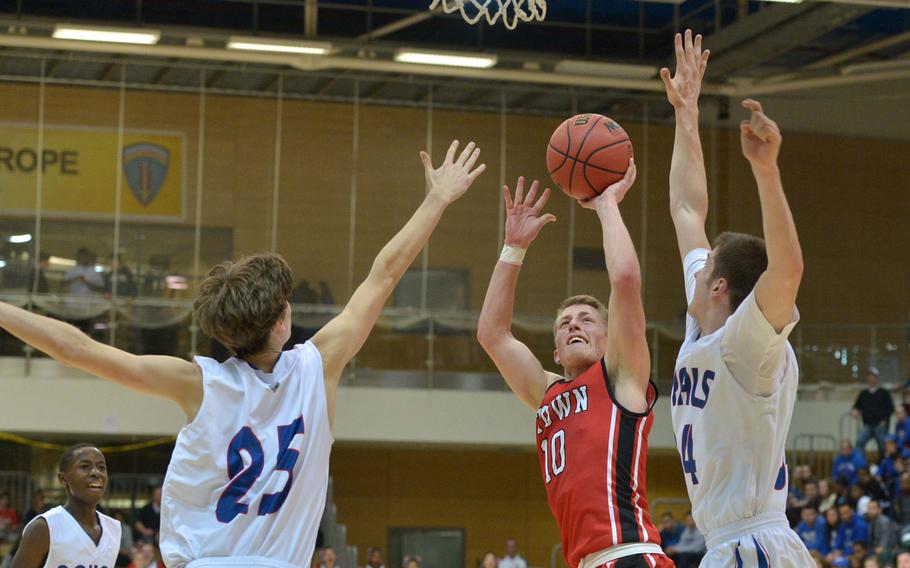 Kaiserslautern's Caleb Chastain shoots over the Ramstein defense of Mitchel McKinney, left, and Jesse Gray in the boys Division I championship game at the DODDS-Europe basketball championships in Wiesbaden, Germany, Saturday Feb. 21, 2015. Ramstein beat Kaiserslautern 47-32 for the title.
