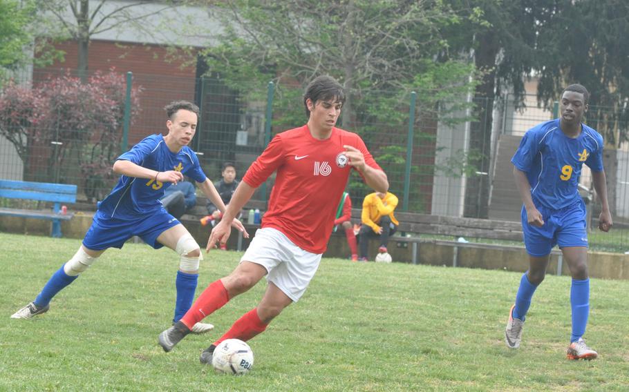 American Overseas School of Rome's Max Suschetet dribbles up the field between Ansbach defenders in the Falcons 2-1 victory on Saturday.