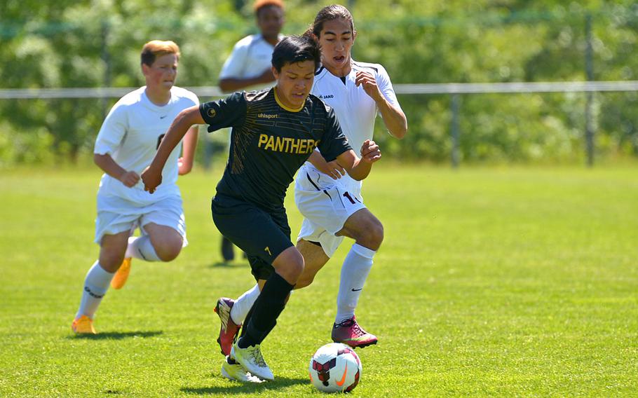 Patch's David Humphreys, left, drives up the field against Vilseck's Eduardo Castaneda in opening-day Division I action at the DODDS-Europe soccer finals in Reichenbach, Germany.Patch won the game 7-0.