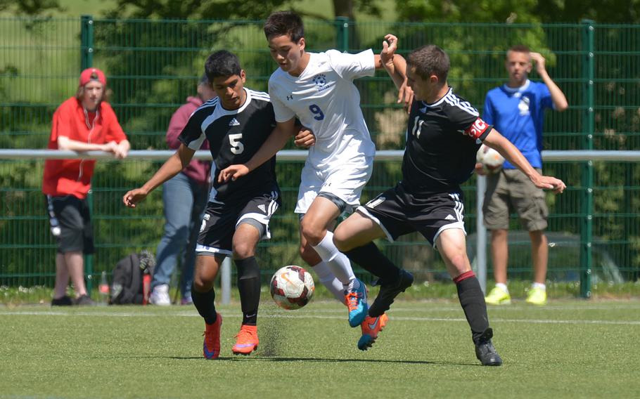Wiesbaden's Richard Edwards tries to get past the Vicenza defense of Christian Gallegos, left, and Sam Ney in opening-day Division I action at the DODDS-Europe soccer finals in Reichenbach, Germany. The game ended in a 2-2 tie.
