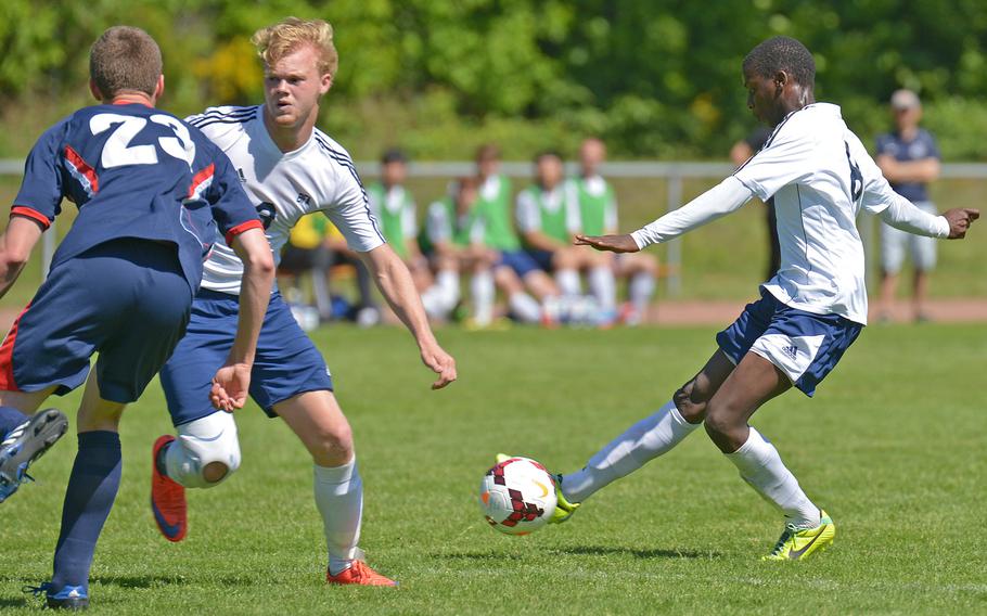 Black Forest Academy's Sam Mussee takes a shot on goal past teammate Dylan Sosso and Aviano's Ehron Capps  in opening-day Division II action at the DODDS-Europe soccer finals in Landstuhl, Germany.BFA won the game 2-0.