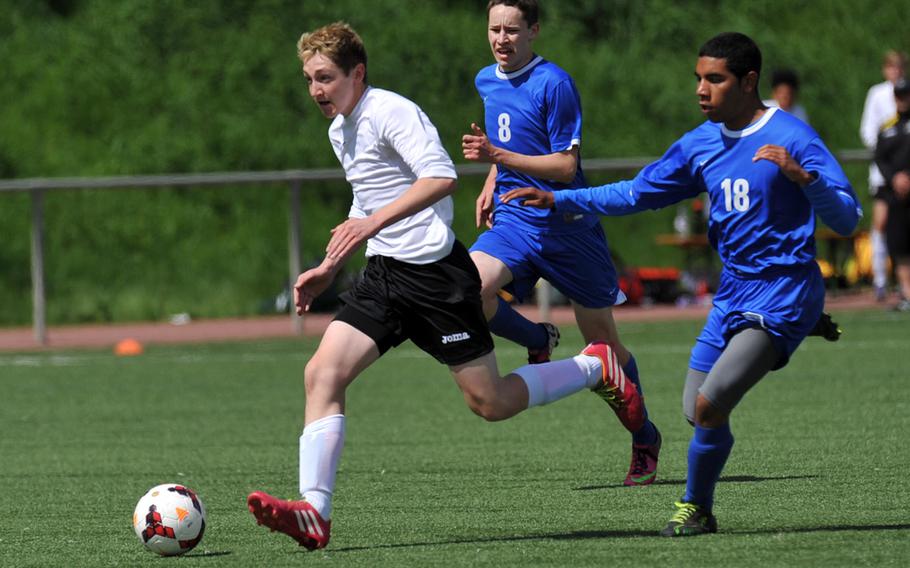 Alconbury's Nathan Dallaire gets away from Joseph Rudy, center, and Eddy Juvier in a Division III game at the DODDS-Europe soccer championships at Landstuhl, Germany. Alconbury won 6-2.