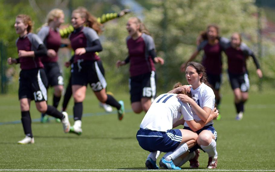 AFNORTH Lions celebrate their win as Black Forest Academy's Hannah Harrop consoles teammate Cailynn Campbell after she knocked the ball into her own goal giving AFNORTH the 1-0 win in a Division II semifinal at the DODDS-Europe soccer championships at Reichenbach, Germany. AFNORTH advances to Thursday's final against Hohenfels.