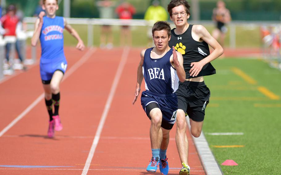 Black Forest Academy's Jacob Benjamin  leads Alexander Bowman of Patch over the finish line in a thrilling boys 3,200-meter race at the DODDS-Europe track and field championships in Kaiserslautern, Germany, Friday, May 22, 2015. Ramstein's John Casey, left, and Bowman exchanged leads throughout the race but Benjamin spurted to victory in 10 minutes 11.40 seconds.